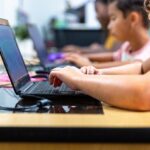 children typing on a laptop