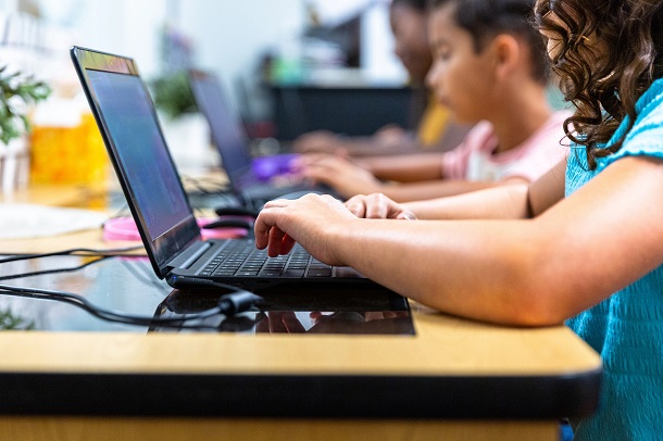 children typing on a laptop